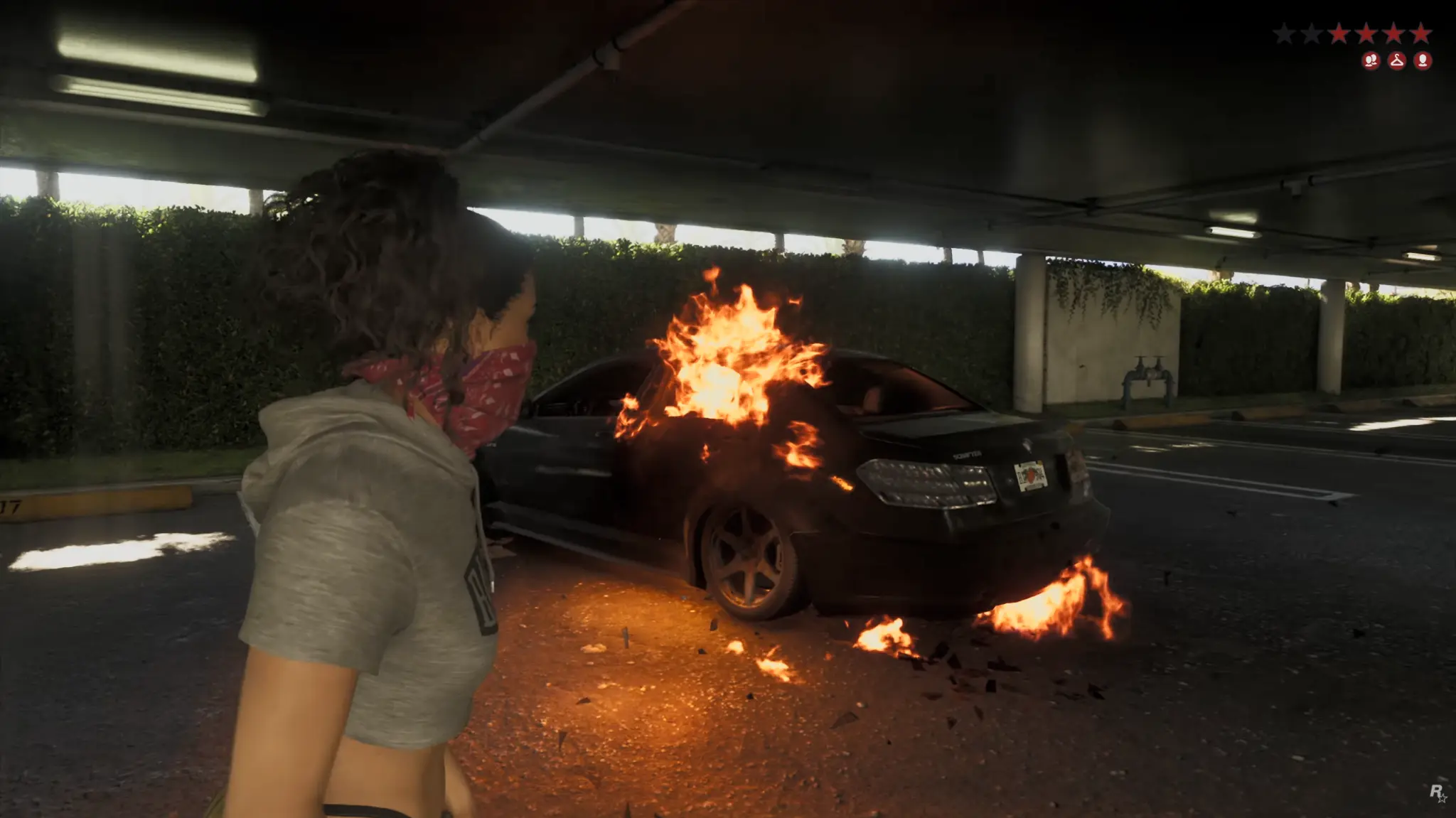 Lucia junto a un coche en llamas con un nivel de búsqueda activo en GTA VI